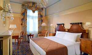 Elegant hotelværelse med dobbeltseng, skrivebord og stort vindue med gardiner. (AI-genereret tekst)