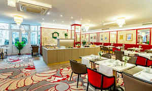 Interiør af en spisesal med dækkede borde og en buffet i baggrunden. (AI-genereret tekst)