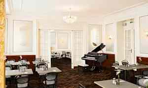 Et elegant indrettet rum med et flygel og opstillede caféborde og -stole. (AI-genereret tekst)