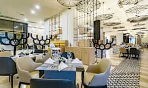 En moderne restaurant med elegante møbler og et stilfuldt loft. (AI-genereret tekst)