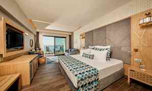 Hotelværelse med moderne indretning, dobbeltseng og altan med havudsigt. (AI-genereret tekst)