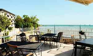 Udendørs servering med udsigt over havet og kystlandskabet. (AI-genereret tekst)