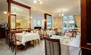 Restaurant med opdækkede borde og stole indendørs. (AI-genereret tekst)