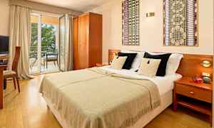 Dobbeltværelse med dobbeltseng, udsigt til altan med siddepladser. (AI-genereret tekst)