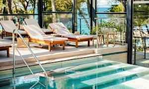 Liggestole ved en pool med udsigt til havet. (AI-genereret tekst)