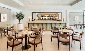 Moderne bar med elegante borde og stole i en lys indretning. (AI-genereret tekst)