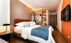 Moderne hotelværelse med dobbeltseng, dekorative puder og belysning. (AI-genereret tekst)