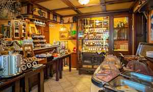 En interiør af en restaurant eller café med en buffetbord og vinflasker i en hylde. (AI-genereret tekst)