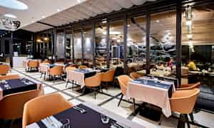 Restaurant med moderne interiør og store glaspartier. (AI-genereret tekst)