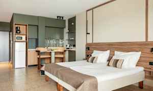 Et værelse med seng, bord og tekøkken. (AI-genereret tekst)