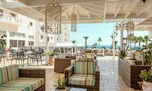 Terrasse med siddepladser og udsigt til havet. (AI-genereret tekst)