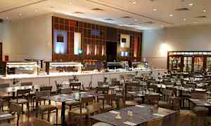 En restaurant med buffetområde og spiseborde. (AI-genereret tekst)