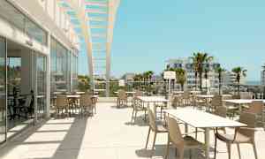 Udendørs serveringsområde med borde og stole under en åben struktur, med udsigt til palmer og bygninger. (AI-genereret tekst)