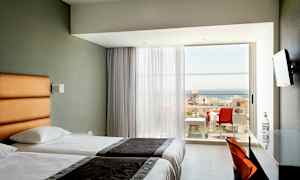 Hotelværelse med to enkeltsenge og balkon med havudsigt. (AI-genereret tekst)