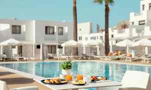 En morgenmad serveret ved et bord med udsigt til en pool og liggestole. (AI-genereret tekst)