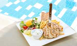 En tallerken med kylling, pommes frites, pitabrød og salat ved siden af en pool. (AI-genereret tekst)