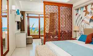 Hotelværelse med seng, dekorativ træpanel og udsigt over havet. (AI-genereret tekst)