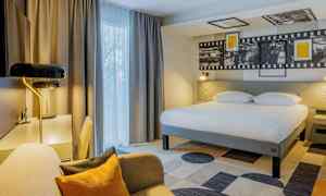 Hotelværelse med stor seng, skrivebord og siddeområde. (AI-genereret tekst)