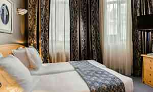 Et hotelværelse med to enkeltsenge, lyse gardiner og en dekorativ sengeløber. (AI-genereret tekst)