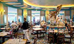 En restaurant med siddepladser og en dekoration i form af en havfigur i midten. (AI-genereret tekst)