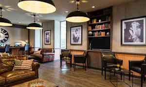 En stilfuld lounge med lædermøbler og kunst på væggene. (AI-genereret tekst)