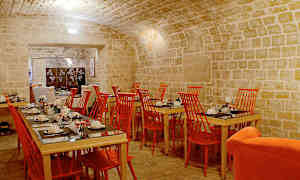 Spisesal med hvælvede stenlofter, røde stole og dækkede borde. (AI-genereret tekst)