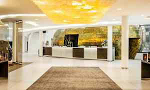 Reception i en moderne hotellobby med en stilfuld gylden indretning og lys dekoration. (AI-genereret tekst)