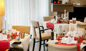 Restaurantbord med juledekorationer, dækket med servietter og glas. (AI-genereret tekst)