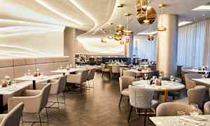 En elegant restaurant med moderne indretning og borde dækket til gæster. (AI-genereret tekst)