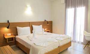 To senge med hvidt sengetøj, en træhovedgærde og dekorative håndklæder formet som svaner. (AI-genereret tekst)