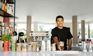 En bardisk med diverse flasker, redskaber og serveringstilbehør. (AI-genereret tekst)