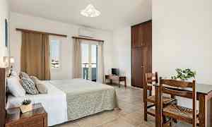 Et soveværelse med en dobbeltseng, et lille bord med to stole og et skab. (AI-genereret tekst)