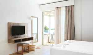 Et hotelværelse med to senge, en TV, et spejl og en balkon. (AI-genereret tekst)