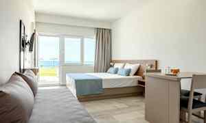 Moderne hotelværelse med seng, sofa og spisebord, havudsigt uden for vinduet. (AI-genereret tekst)