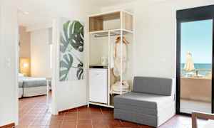 Moderne hotelværelse med siddeplads, åben garderobe og havudsigt. (AI-genereret tekst)