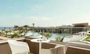 Udsigt over en pool og siddeområde fra en balkon. (AI-genereret tekst)