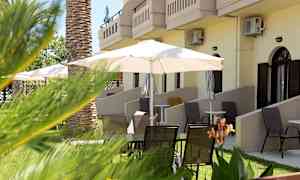 Terrasseområde med stole og parasoller foran bygningen. (AI-genereret tekst)