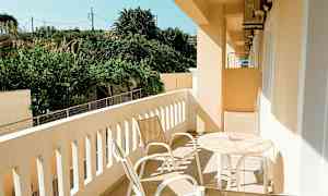 En altan med haveudsigt, møbleret med bord og stole. (AI-genereret tekst)