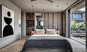 Moderne soveværelse med stor seng og åben glasfacade der vender ud mod terrasse. (AI-genereret tekst)