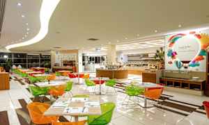 En spisesal med farverige stole og dækkede borde samt en buffet i baggrunden. (AI-genereret tekst)