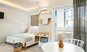 Moderne indrettet hotelværelse med seng, spejl og altandør. (AI-genereret tekst)