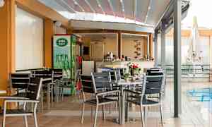 En udendørs servering med borde og stole ved en pool. (AI-genereret tekst)