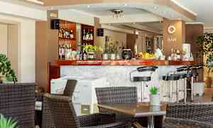 En bar med høje stole og borde foran. (AI-genereret tekst)