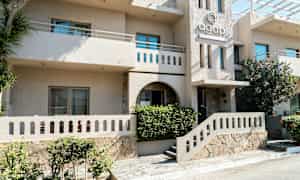 Bygning med indgang til Agapi Resort. (AI-genereret tekst)