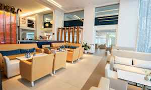 Hotellobby med siddegrupper, borde og moderne indretning. (AI-genereret tekst)