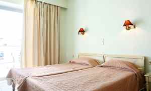 To enkeltsenge med rosa sengetæpper i et rum med vinduesåbning og væglamper. (AI-genereret tekst)