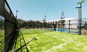 En oplyst udendørs padelbane med et net mellem spilleområderne. (AI-genereret tekst)