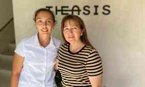 To personer står foran en væg med en logo. (AI-genereret tekst)