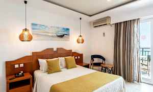 Et hotelværelse med en dobbeltseng, to natborde med lamper og en stol ved siden af et bord. (AI-genereret tekst)