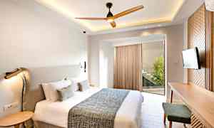 Et moderne soveværelse med en stor seng, et skrivebord og et fjernsyn. (AI-genereret tekst)